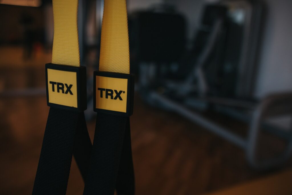 Uchwyty taśm TRX zawieszone w sali treningowej