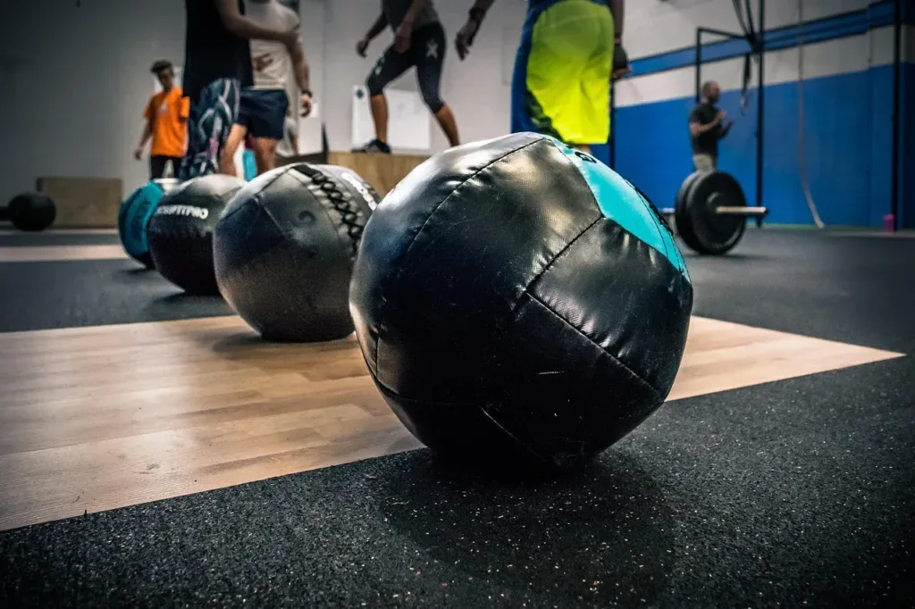 Piłki wall ball na podłodze boxu crossfitowego przed treningiem AMRAP