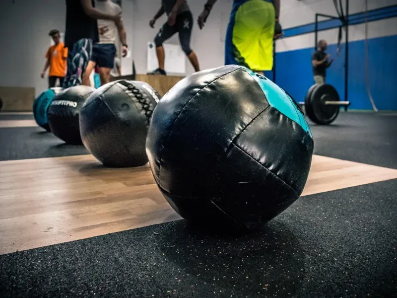 Piłki wall ball na podłodze boxu crossfitowego przed treningiem AMRAP